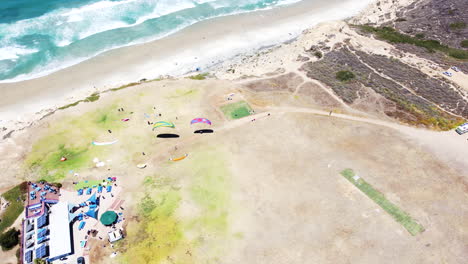 Powered-parachute-sport-at-coastal-cliff-side-in-aerial-drone-view