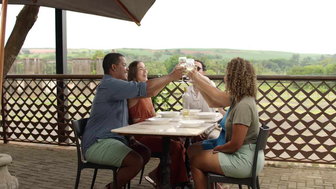 Friends Toasting and Laughing at an Outdoor Restaurant