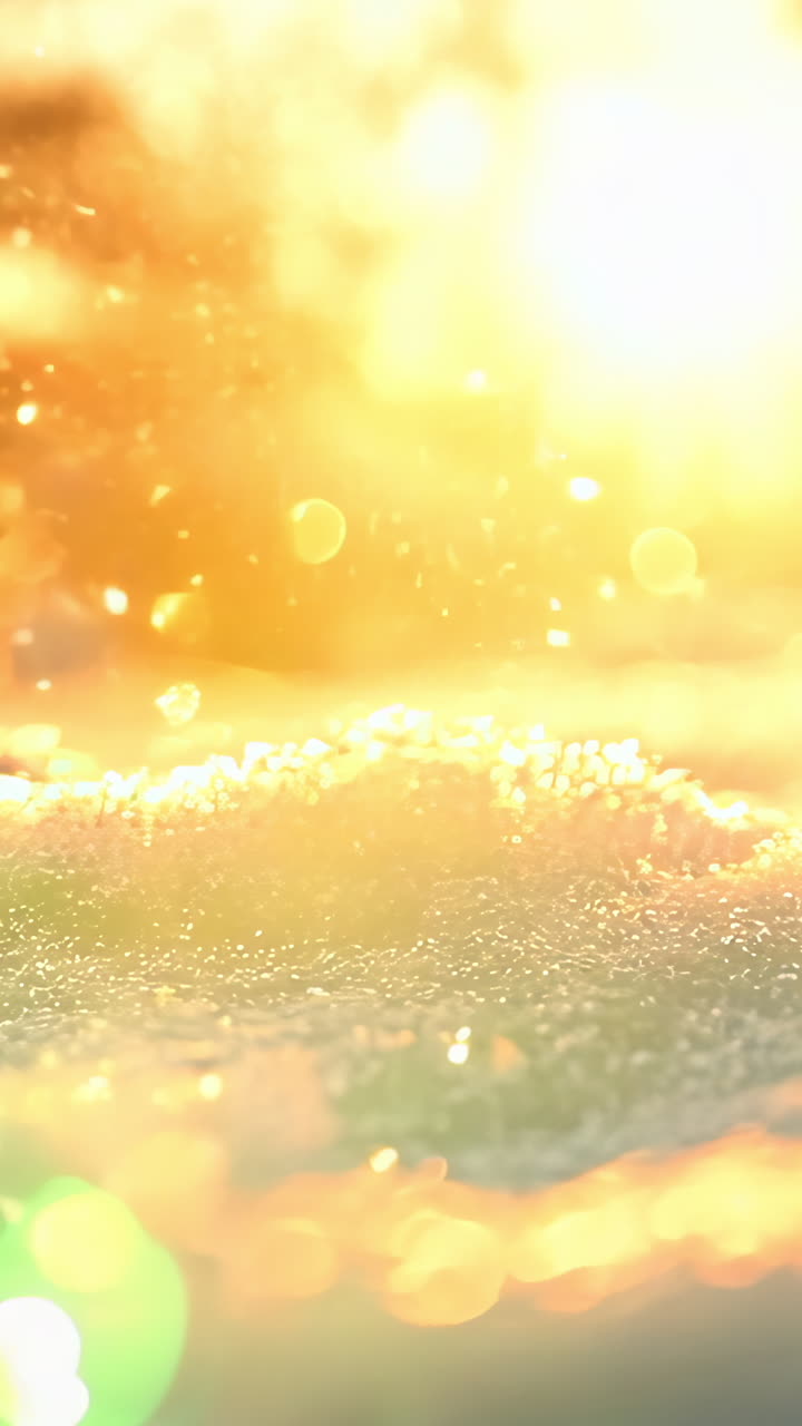 A snow covered landscape with a bright sun in the background. The sun is shining on the snow, creating a beautiful and serene scene