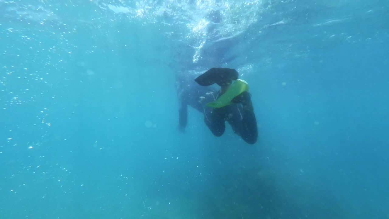 un buzo levanta agua causando burbujas en agua azul cristalina en maracajau en rio grande do norte, brasil