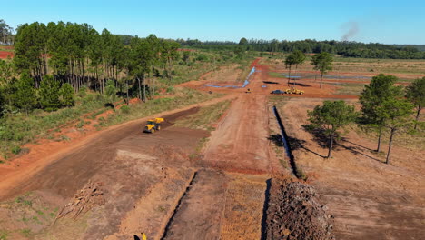 close up drone footage of bulldozers clearing land in argentina. sunlit detail with lush backgrounds. ideal for construction projects or heavy machinery content.
