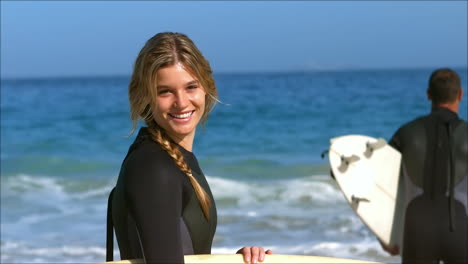woman posing while boyfriend running into water