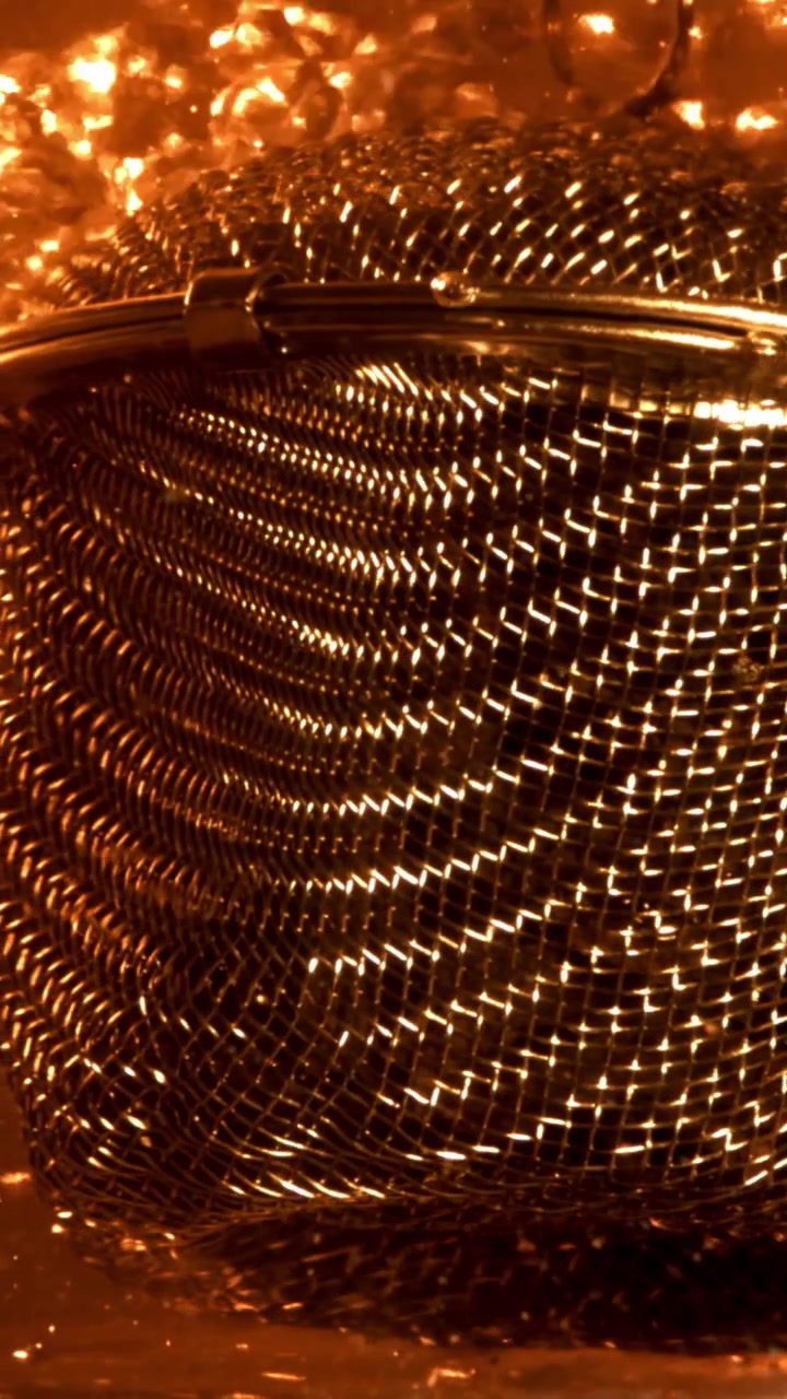 Colino a maglie metalliche dorato in acqua bollente con bolle