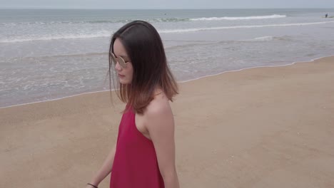 young asian woman wear red dress and walking relaxing on the beach at summer vacation holidays in slowmotion