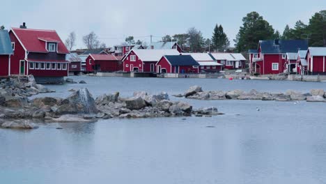 handheld footage of a quaint village with red houses and fishing boats in the swedish archipelago during spring