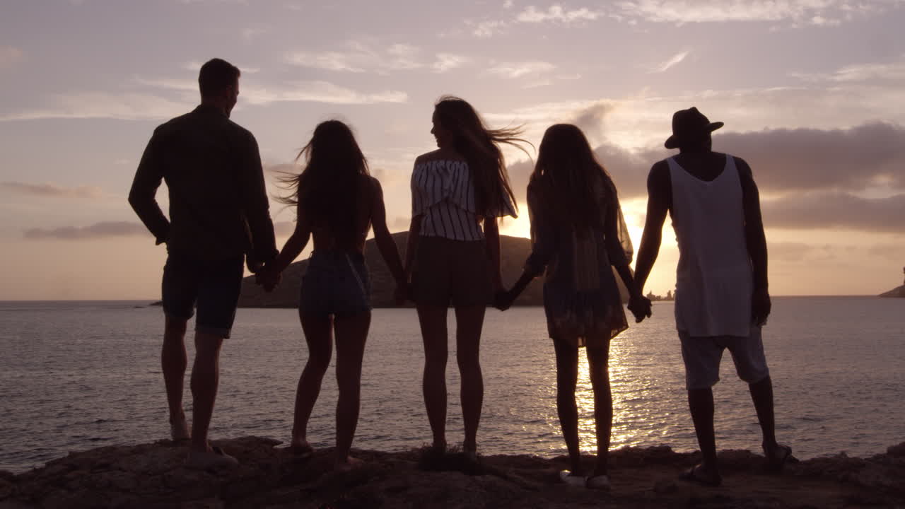 r3d에서 촬영된 해가 지는 것을 지켜보는 절벽에 서 있는 친구들