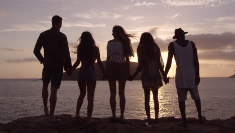 friends standing on cliff watching sunset shot on r3d