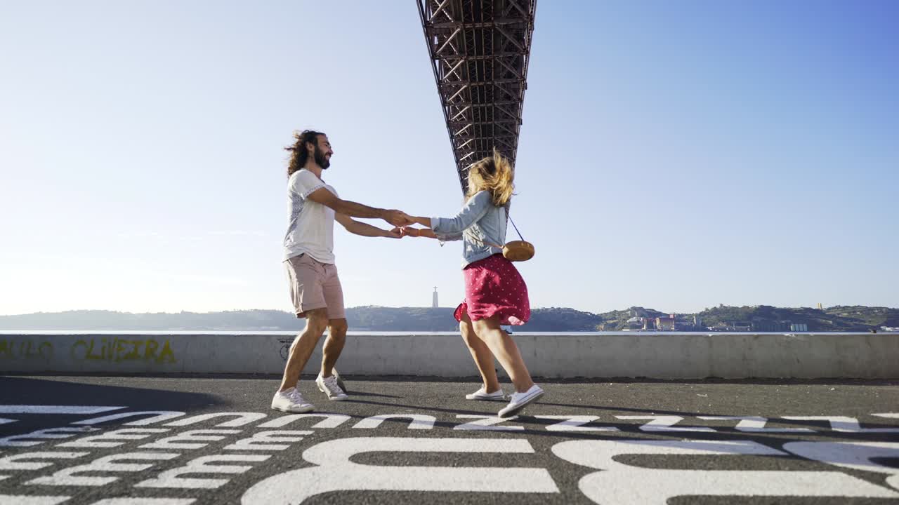 pareja bailando en la carretera cerca del puente