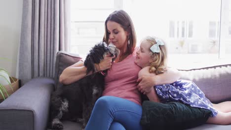 caucasian mother and daughter having fun playing with a dog