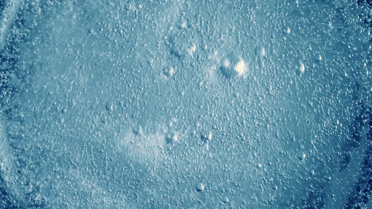 Bolle di ossigeno nell'acqua su uno sfondo astratto blu.