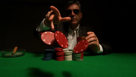 Cool-gambler-throwing-red-chips-to-camera