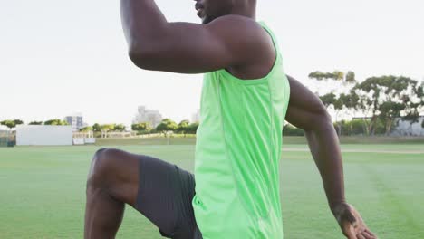 Hombre-Afroamericano-En-Forma-Haciendo-Ejercicio-Al-Aire-Libre-Estirándose-Y-Saltando-Desde-La-Cintura