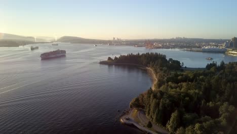 large cargo ship transporting and sailing at the burrard inlet during a bright sunrise in vancouver, canada