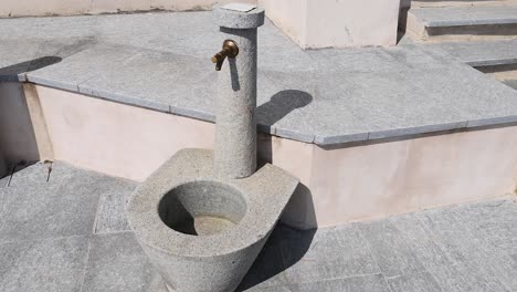 stone fountain with water tap in italy