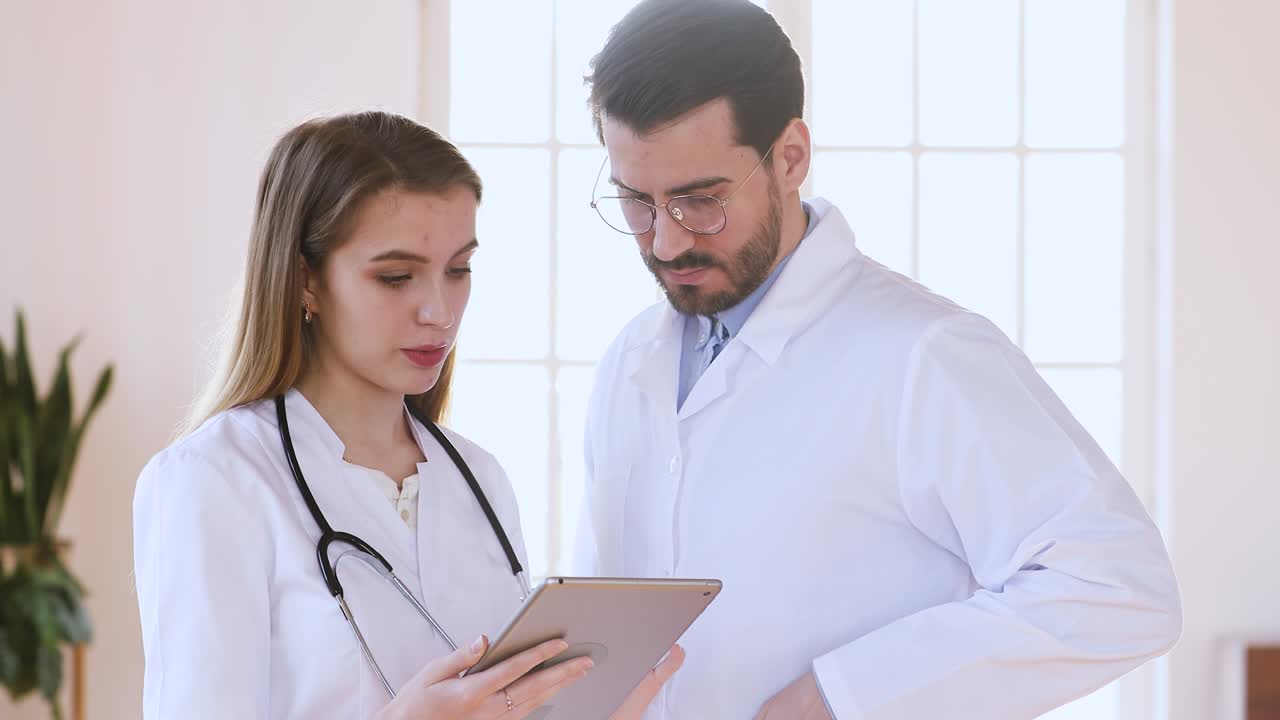 interna de medicina general mujer consultando con el médico jefe masculino.