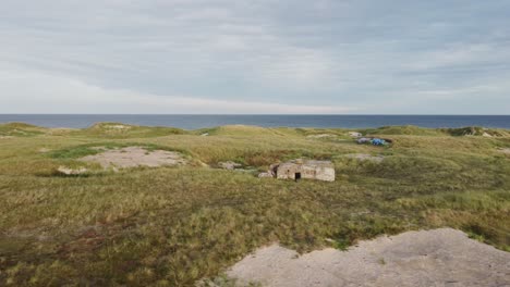 whole outlook of coastal battery klitmöller, a beach bunker in denmark - drone orbit