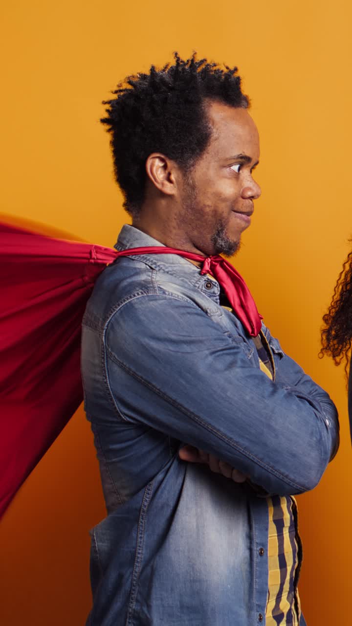 Hombre afroamericano seguro de sí mismo con capa de superhéroe sonriendo