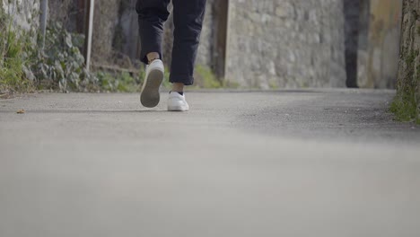 Ground-Shot-Of-Young-Teenager-Foot-Steps-Wearing-Casual-Shoes-And-Anklet