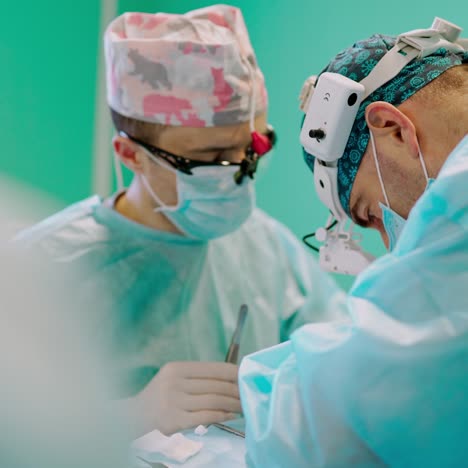 surgical process by specialists. team of doctors in medical uniform perform a surgery to a patient with special tools. medicine concept.