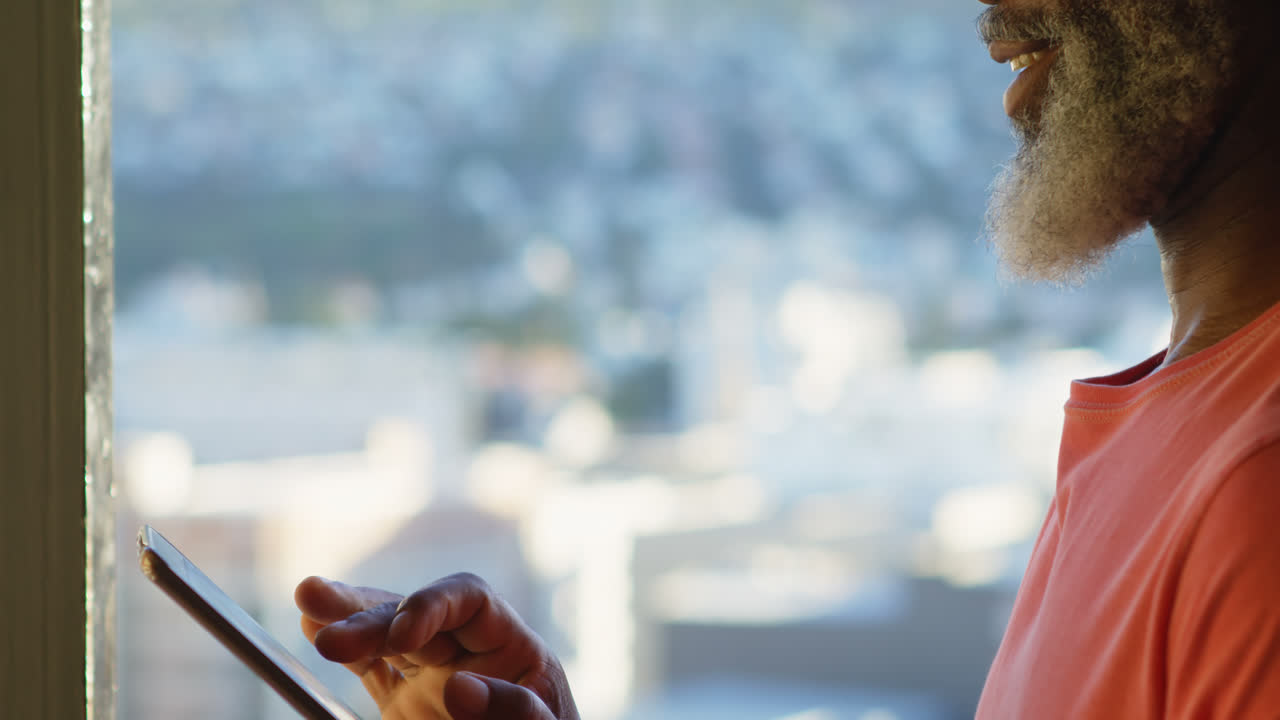 hombre mayor que usa tableta digital en casa 4k