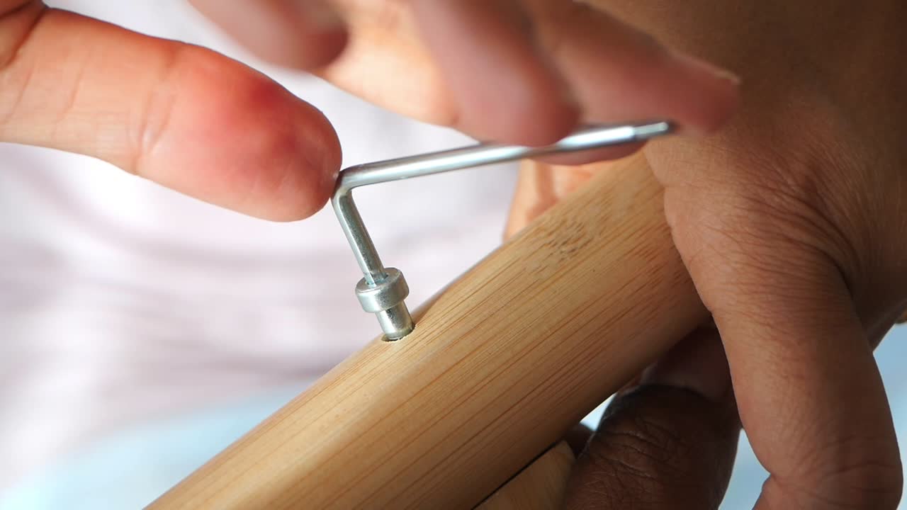 Hands Assembling Wooden Furniture with an Allen Wrench