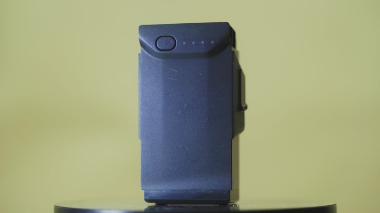 A rotating close up shot of a standing black lithium drone battery, mavic air, slow motion 4K