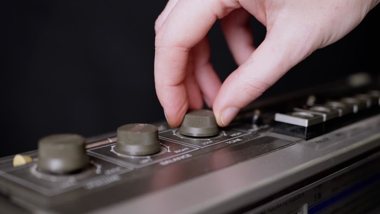 dedos femeninos girando el volumen, botones de equilibrio en una vieja grabadora de cinta. 4k