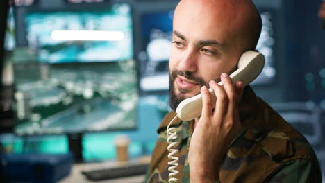 Military-soldier-in-mission-control-center-answering-telephone-call