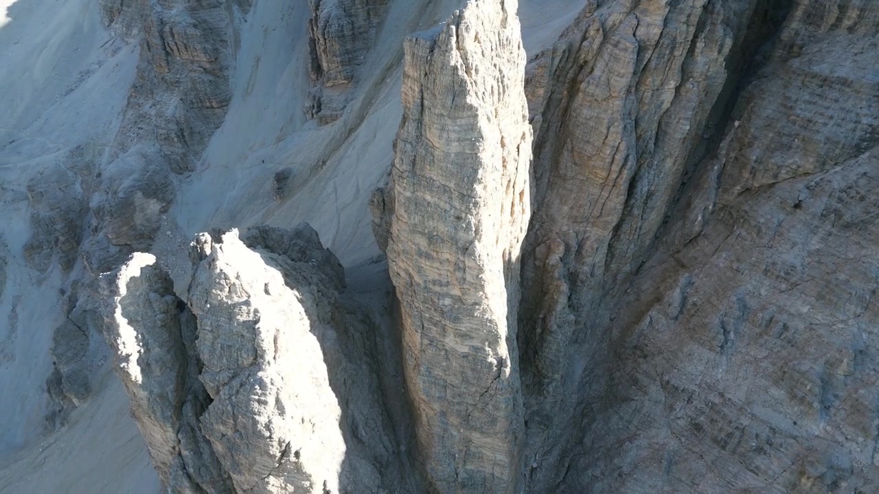 Filmagens aéreas de drone de Tofana di Rozes, Itália: imponentes falésias de calcário, cristas rochosas e espetacular paisagem das Dolomitas sob um céu limpo. Ideal para projetos de natureza, viagens e atividades ao ar livre
