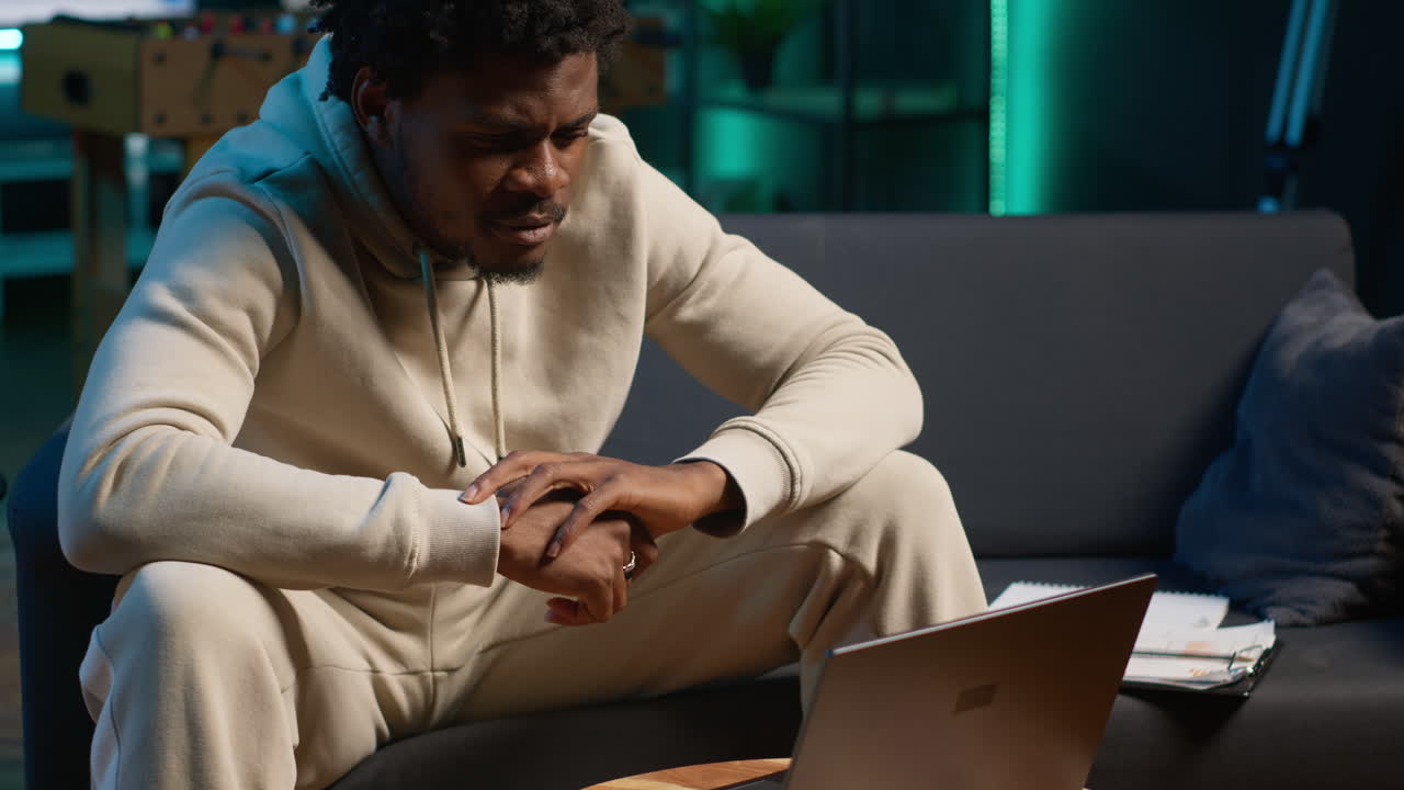 Confident young man solving daily tasks on a freelance platform at home, answering emails and multitasking. Person staying connected and enjoying the flexibility of working remotely. Camera A.