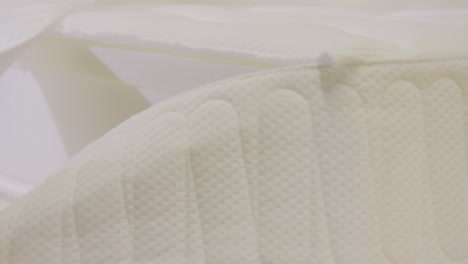 close-up of hands arranging a mattress in a boxspring bed factory, quality inspection