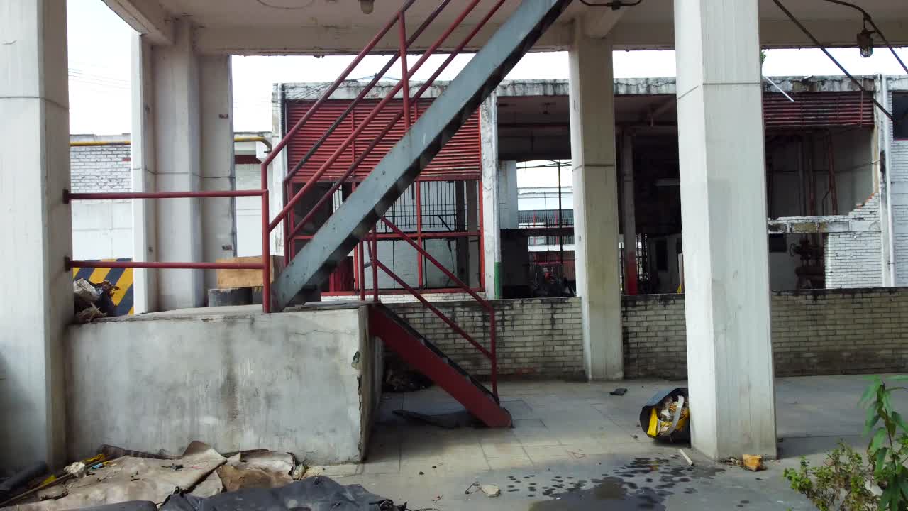 la cámara del drone se desplaza lentamente, revelando la cavernosa extensión del piso de la fábrica