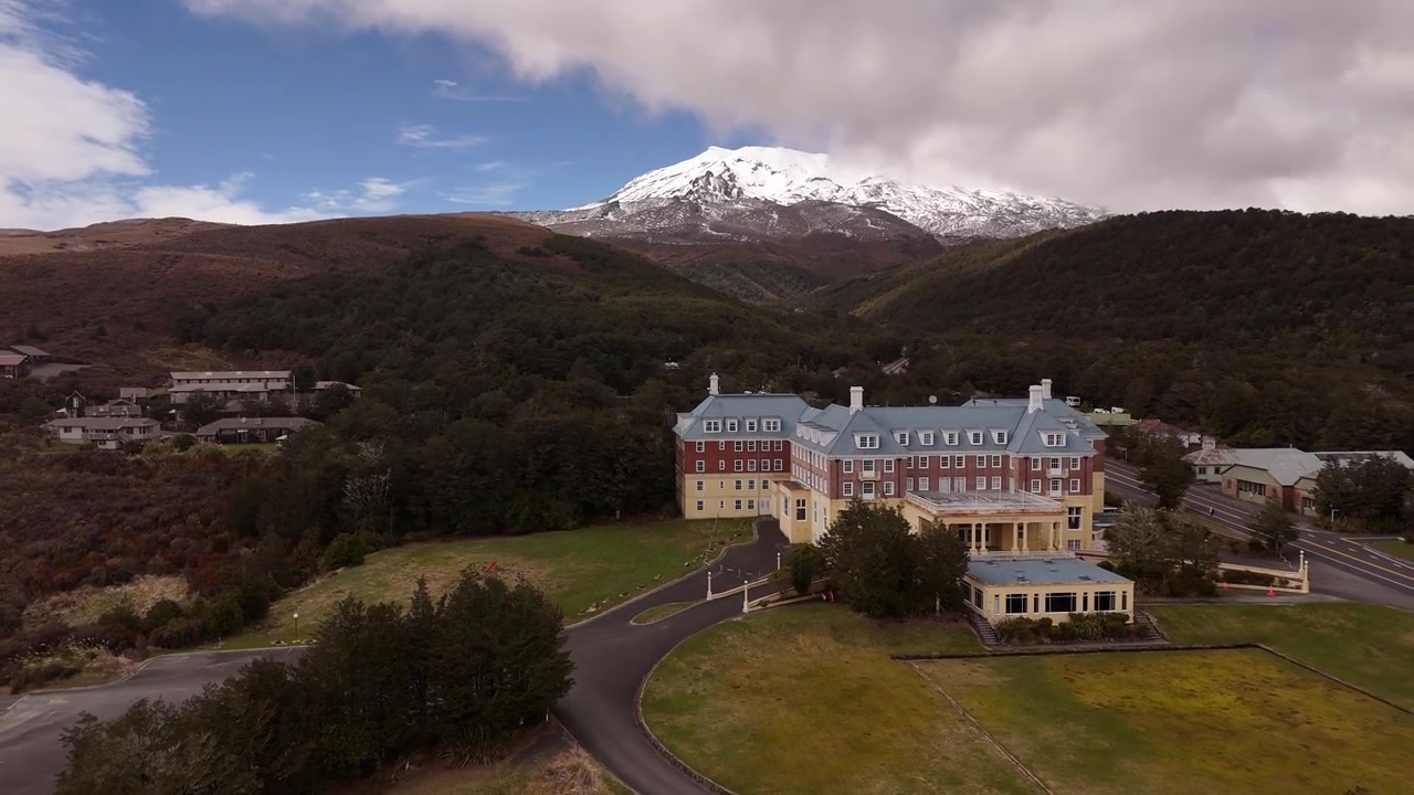 Yeni Zelanda, Tongariro Milli Parkı'ndaki Chateau Tongariro Tarihi Oteli ve karla kaplı dağ zirvesi