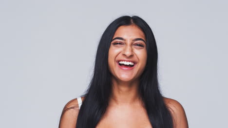 Foto-De-Estudio-De-Cabeza-Y-Hombros-De-Una-Mujer-Haciendo-Muecas-Y-Sonriendo-A-La-Cámara-En-Cámara-Lenta