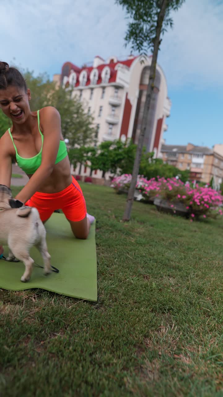 mujer haciendo yoga en el parque con el perro