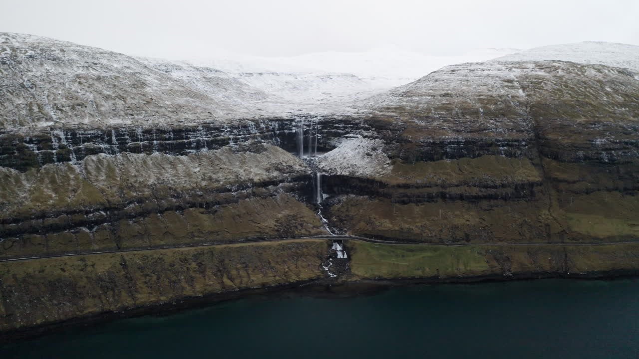 Faroe Islands, 4K Aerial wide push in of beautiful Foss&aacute; waterfall