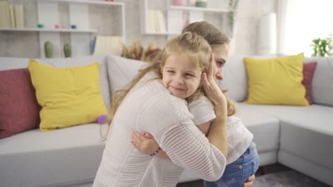 The-mother-hugging-and-kissing-her-daughter-at-home-is-happy.