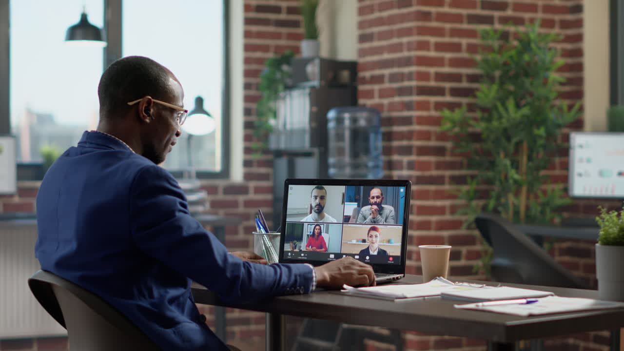 Young businessman attending teleconference meeting on laptop