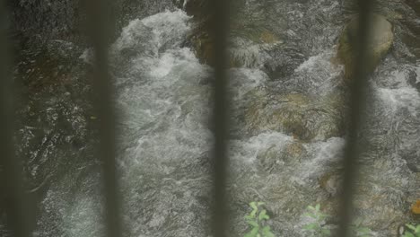 water rapids seen through steel railing