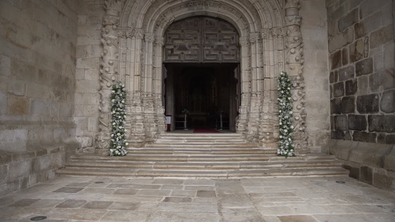 Elegant wedding entrance with floral decor at a historic church doorway