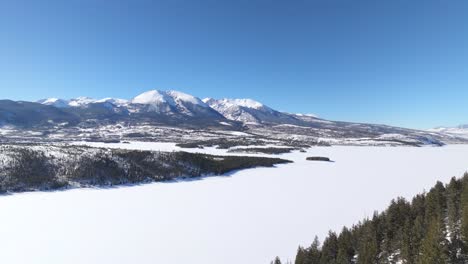 aerial view of snowy mountain peaks and frozen lake