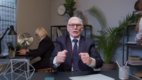 upset business man loudly yells waving hands from rage at office workplace, screaming angry, furious