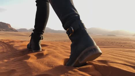 toma en cámara lenta de una mujer caminando sobre una duna de arena en el desierto de wadi rum, jordania