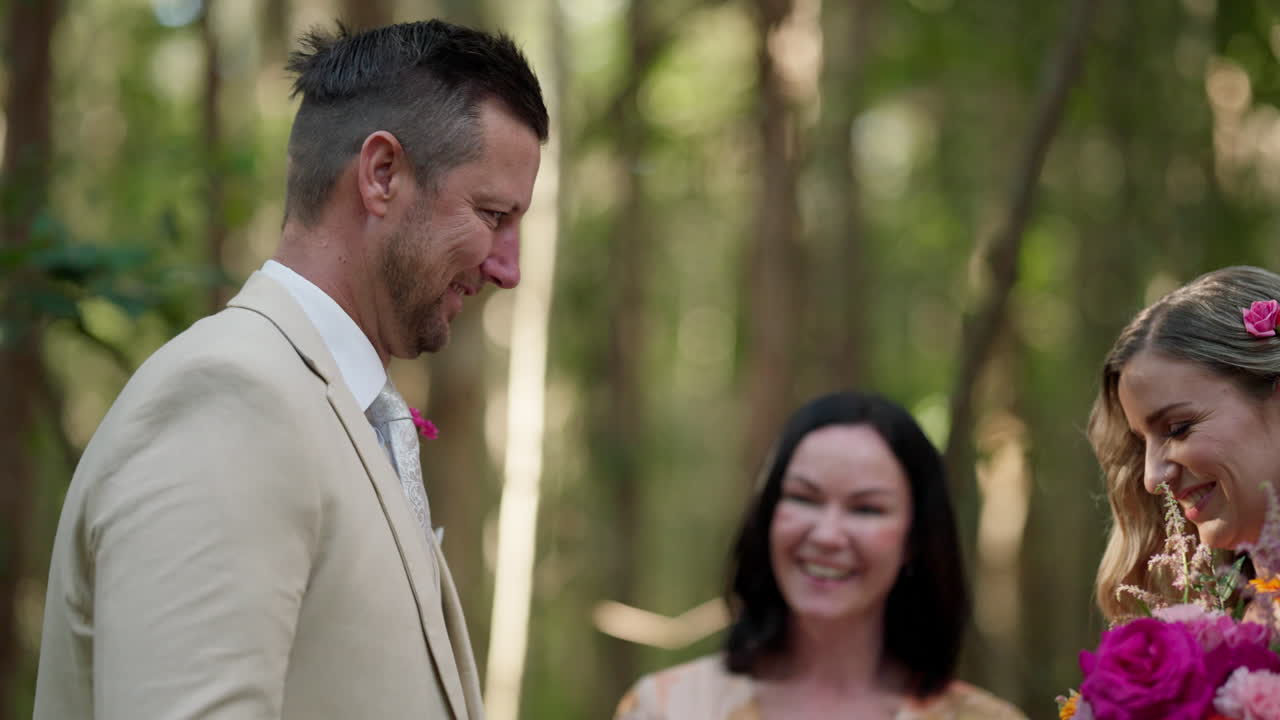 Groom Smiling At New Bride During Wedding Ceremony In Green Nature Background, 4K Slow Motion