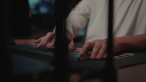 persona escribiendo en un teclado por la noche
