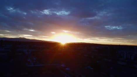 Rayos-De-Sol-A-Través-De-Las-Nubes-Sobre-El-Paisaje-Urbano,-Disparo-De-Drones-1