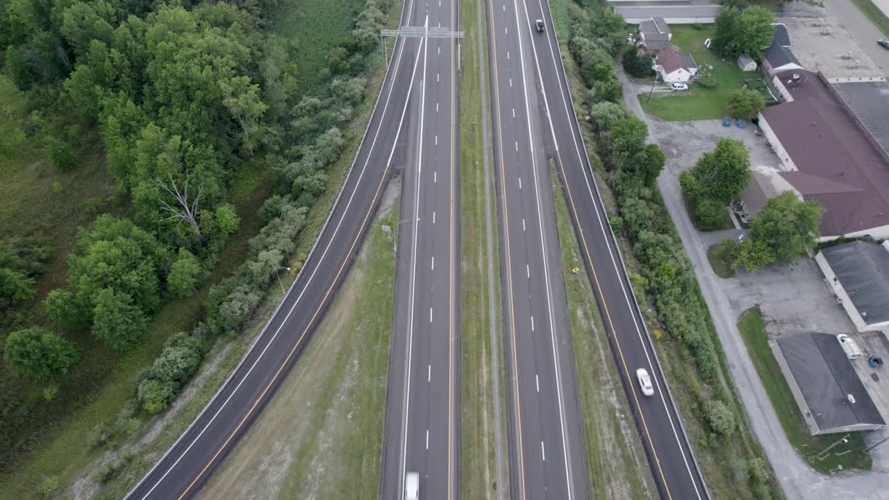 낮에는 한쪽 건물과 무성한 녹색 초목이 있는 고속도로와 도로 교차로에서 높은 각도로 촬영