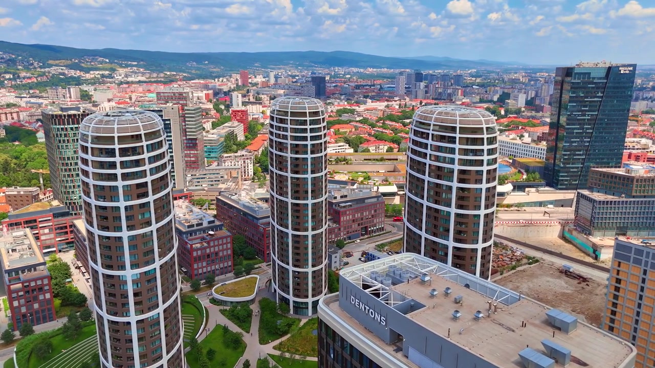 Bratislava, Slovacchia, 2 giugno 2026: Luce diurna su torri residenziali contemporanee, Bratislava, Slovacchia. Vista aerea di grattacieli curvi circondati da prati verdi e strade urbane