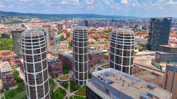 Bratislava, Slovacchia, 2 giugno 2026: Luce diurna su torri residenziali contemporanee, Bratislava, Slovacchia. Vista aerea di grattacieli curvi circondati da prati verdi e strade urbane
