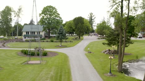 Long-driveway-revealing-a-beautiful-farm-house,-pond,-and-barn-in-the-country-in-Wisconsin